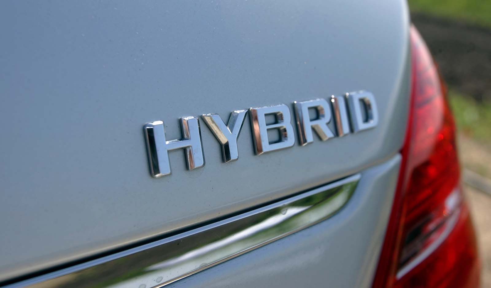 Back of a silver car with large hybrid logo